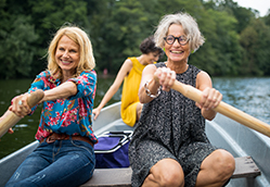 A group of mature women rowing a boat together