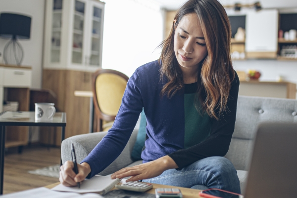 youngAsian woman writing in living room