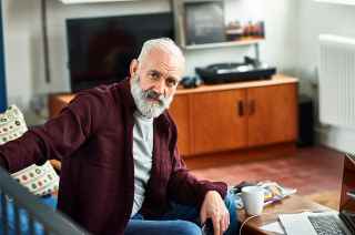 Image of senior man sitting in living room