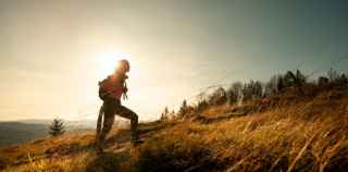 Image of woman hiking up a hill