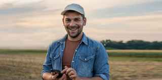 Image of man smiling holding mobile phone