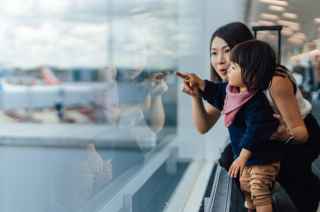 Image of mother and child pointing at planes