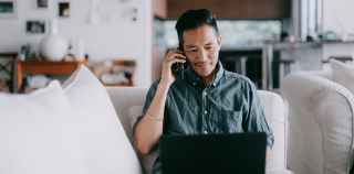 Image of man using laptop and phone